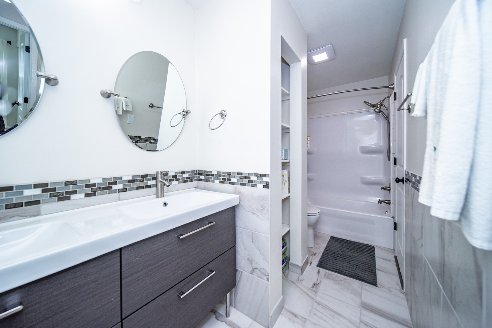 228 Butternut Lane Streamwood, IL 60107 - Photo 5 of 15 a bathroom with a double vanity sink a mirror a bathtub and shower