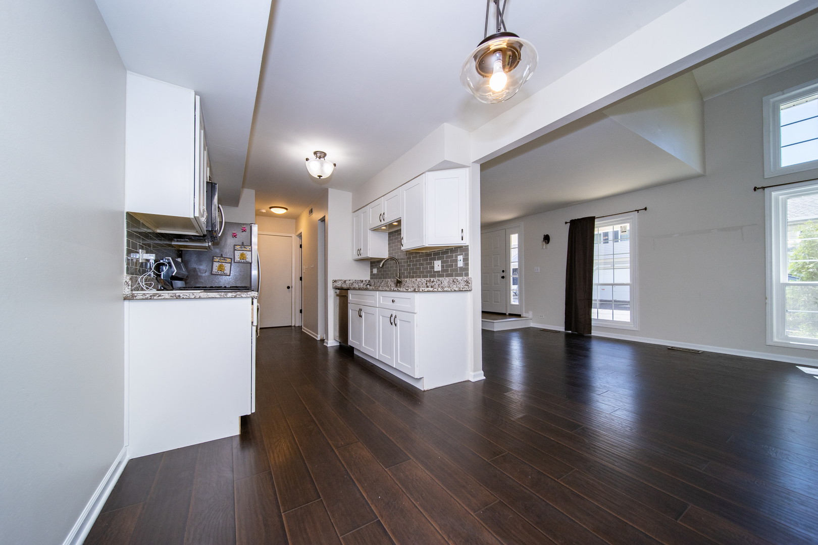 228 Butternut Lane Streamwood, IL 60107 - Photo 7 of 15 a view of an empty room and kitchen with wooden floor
