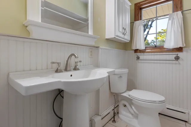 a bathroom with a sink a toilet and a window