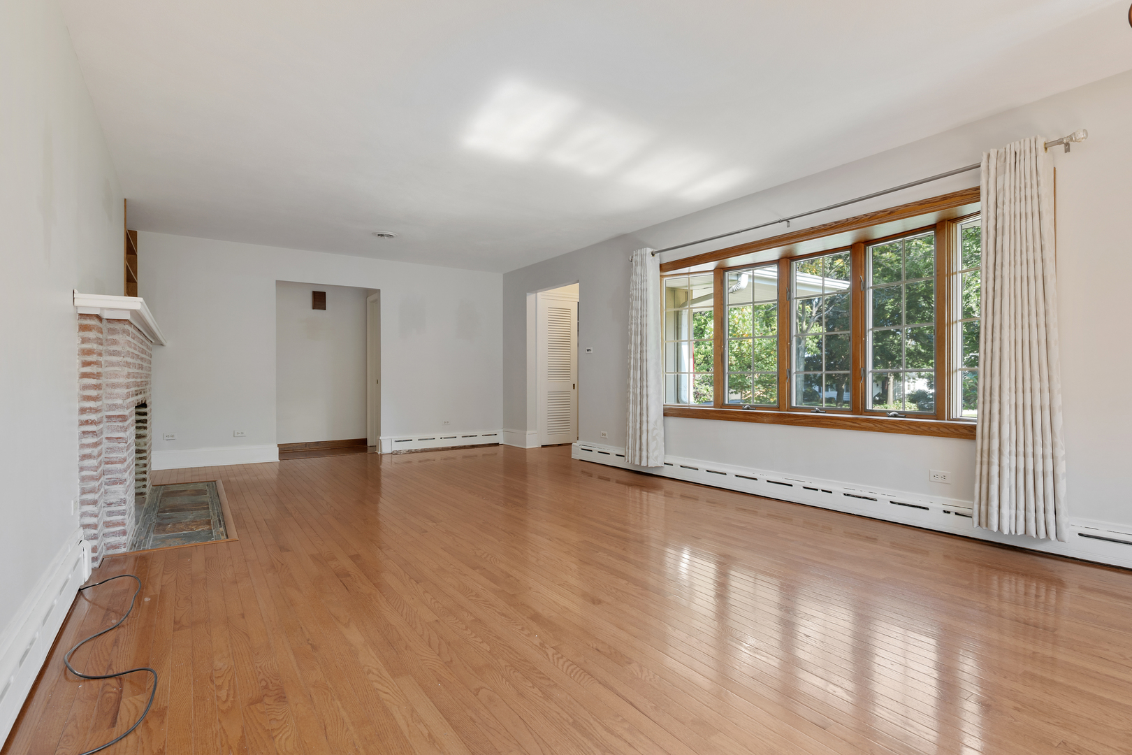 240 Scott Avenue Glen Ellyn, IL 60137 - Photo 5 of 25 a view of an empty room with a window and wooden floor