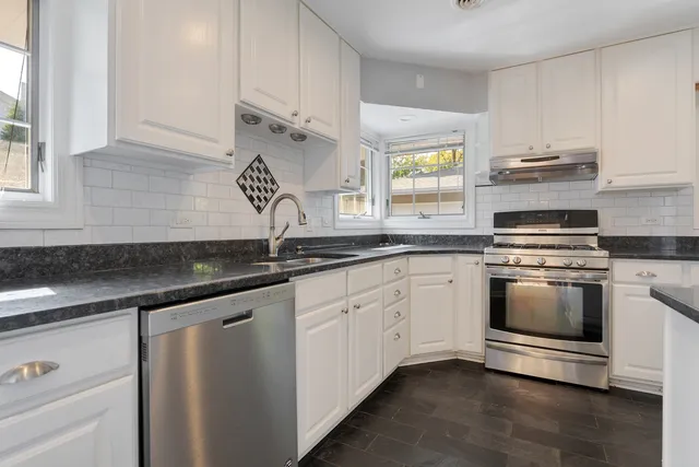 a kitchen with granite countertop white cabinets and appliances