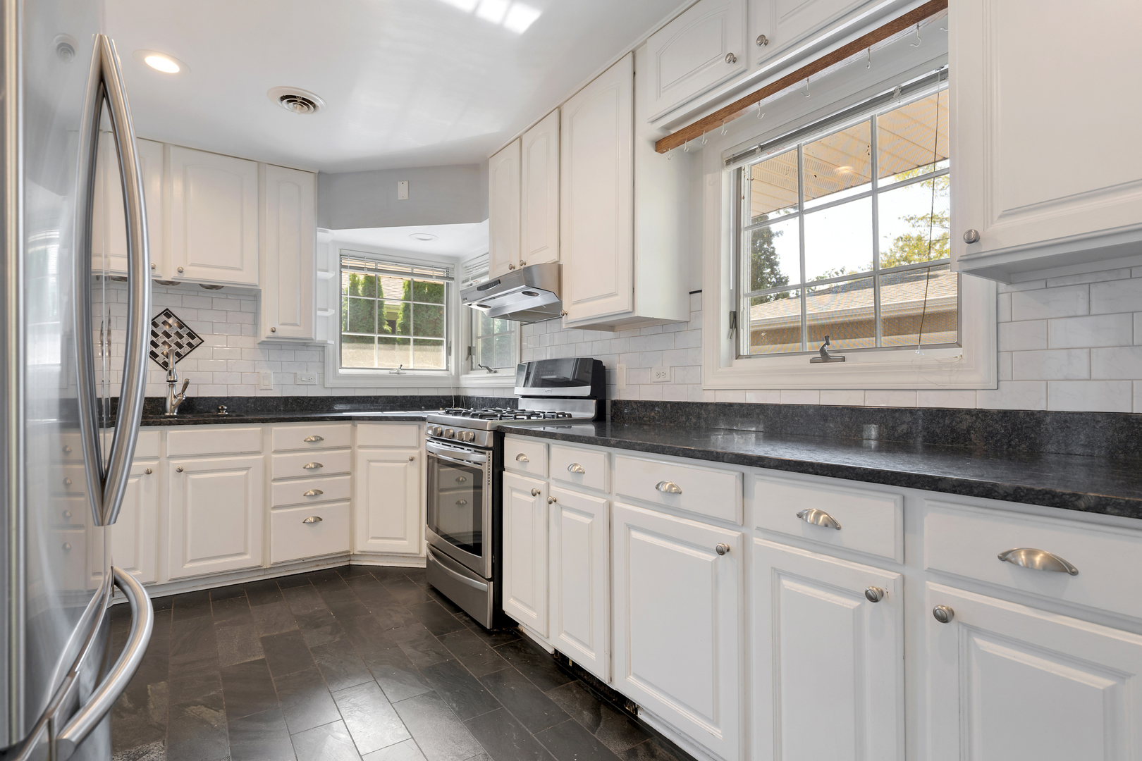 240 Scott Avenue Glen Ellyn, IL 60137 - Photo 9 of 25 a kitchen with granite countertop white cabinets white appliances a sink and a window