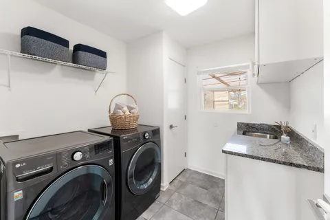 a utility room with sink dryer and washer