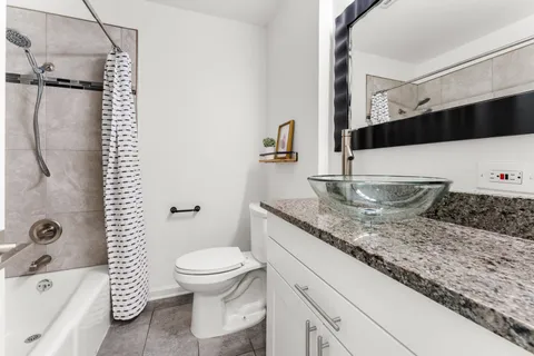 a bathroom with a granite countertop sink toilet and shower