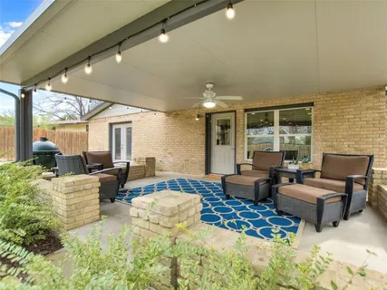 a living room with fireplace furniture and a large window