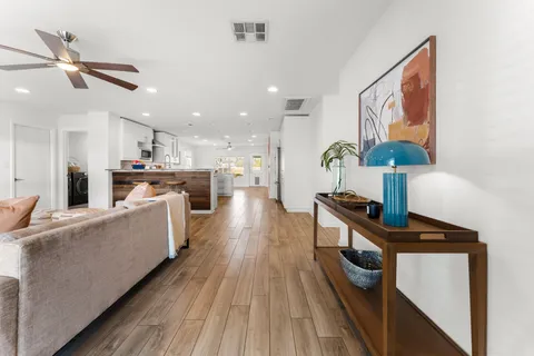 a living room with furniture and a wooden floor