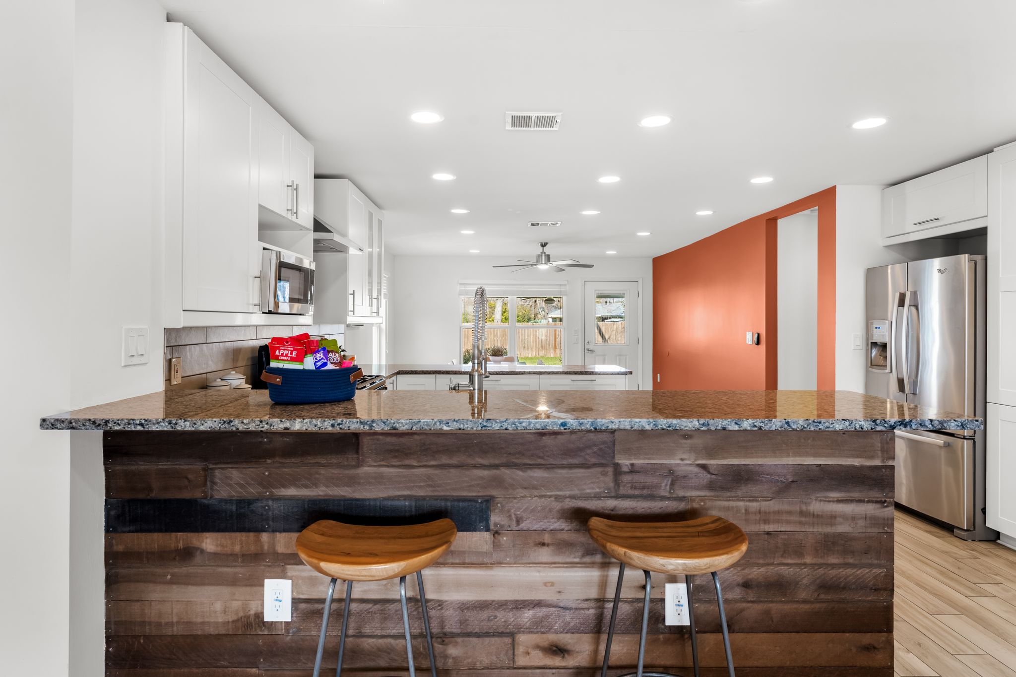 1900 Ohlen Road Austin, TX 78757 - Photo 7 of 34 Kitchen with dark stone countertops, a peninsula, white cabinets, a kitchen breakfast bar, and recessed lighting