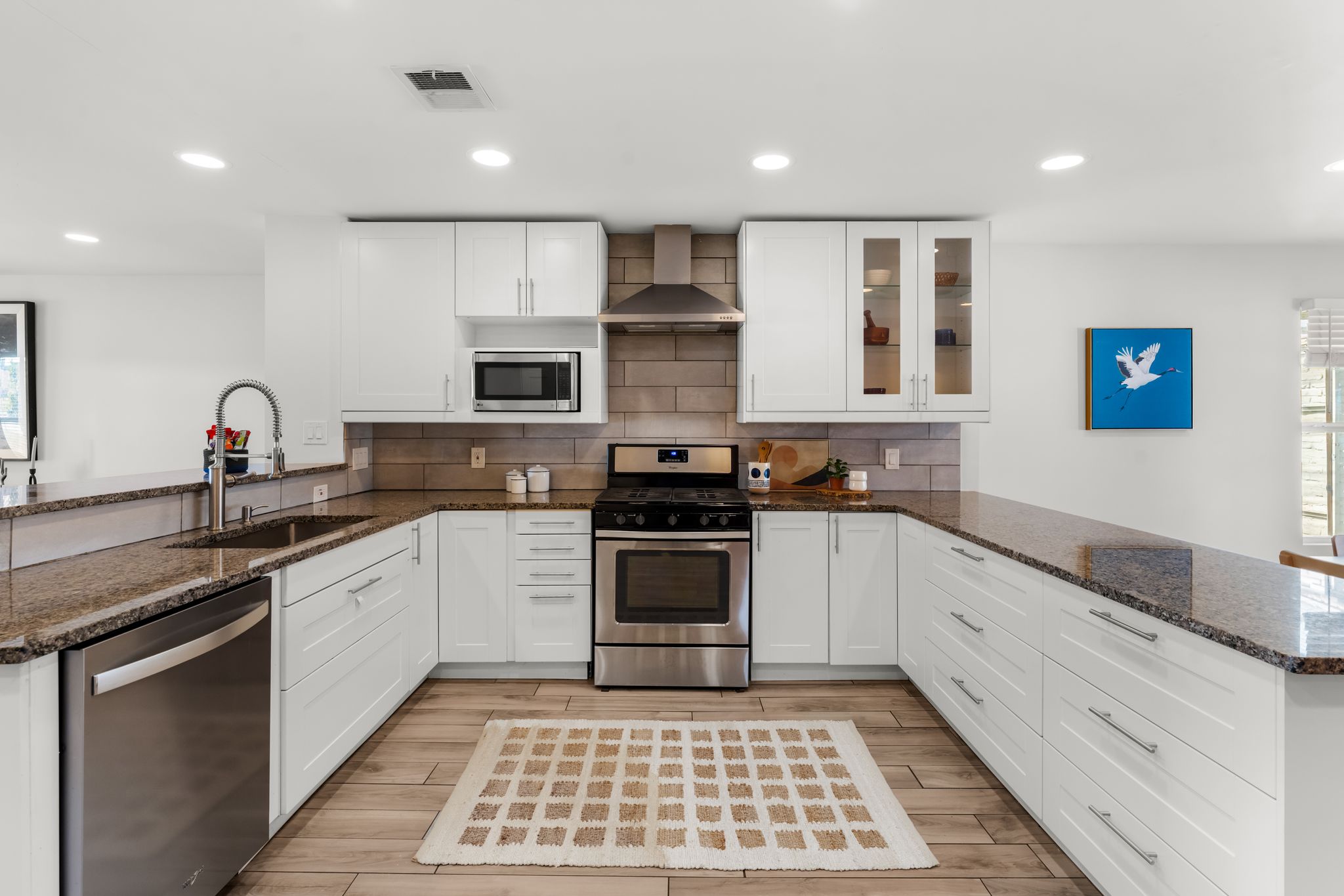 1900 Ohlen Road Austin, TX 78757 - Photo 8 of 34 Kitchen featuring a peninsula, dark stone counters, white cabinets, and recessed lighting