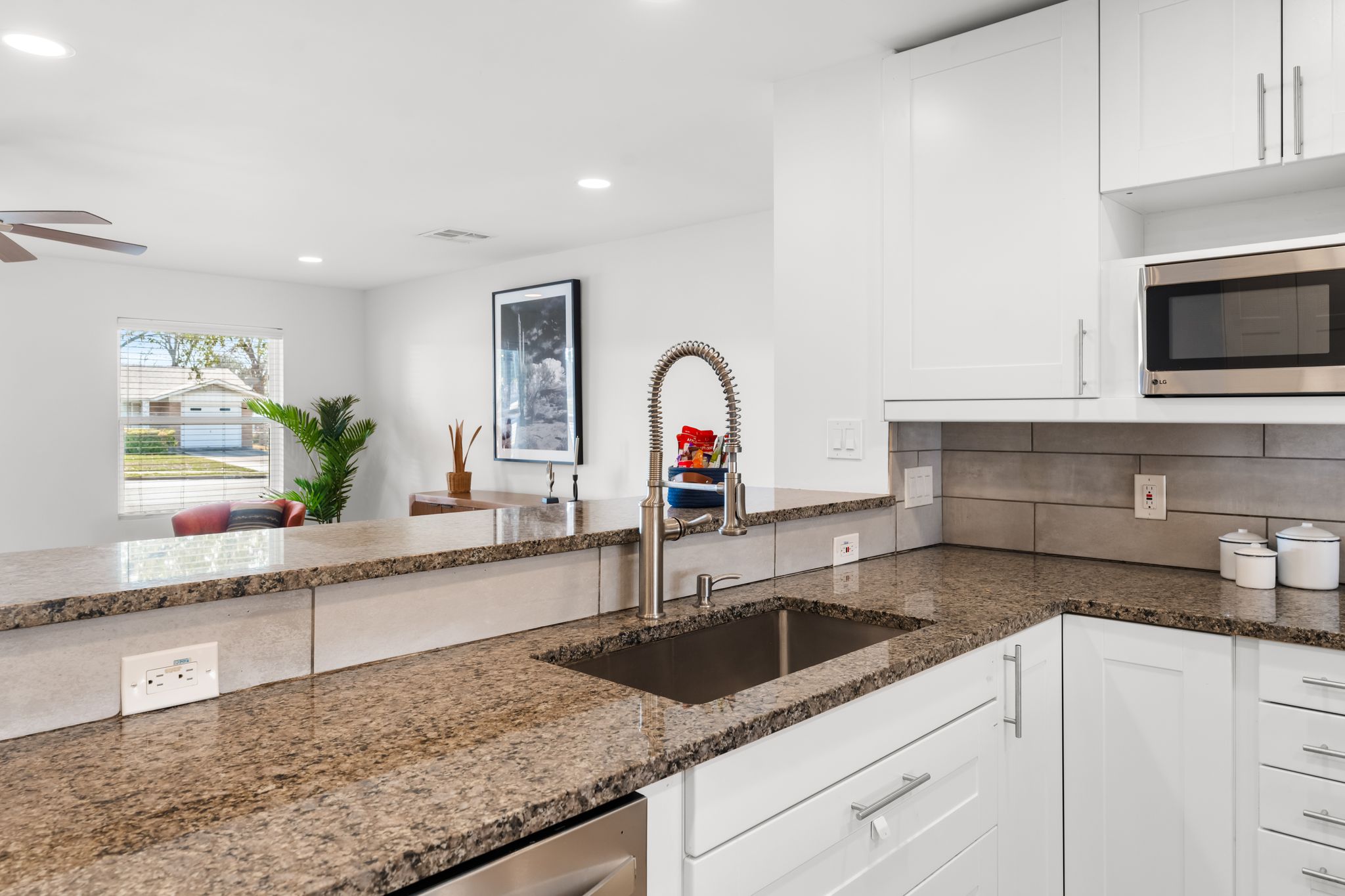 1900 Ohlen Road Austin, TX 78757 - Photo 10 of 34 Kitchen featuring white cabinets, stainless steel appliances, dark stone countertops, ceiling fan, and decorative backsplash