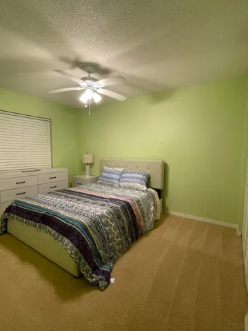 a bedroom with a bed and a ceiling fan