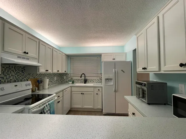 a kitchen with stainless steel appliances granite countertop a refrigerator sink and cabinets