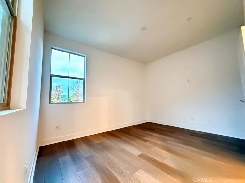 1643 Rosewell Road West Covina, CA 91791 - Photo 24 of 27 an empty room with wooden floor and windows