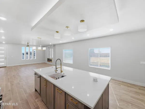 a kitchen with kitchen island a sink appliances and a counter top space