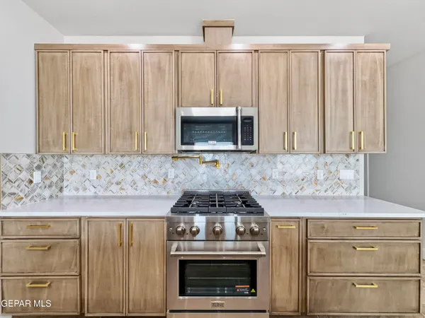a kitchen with granite countertop white cabinets and stainless steel appliances