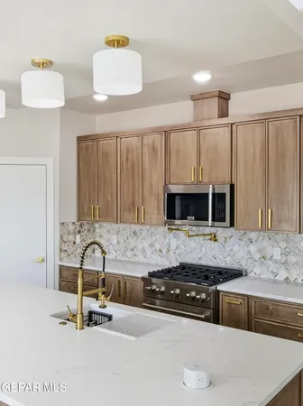 a kitchen with kitchen island granite countertop a stove and a sink with granite countertops