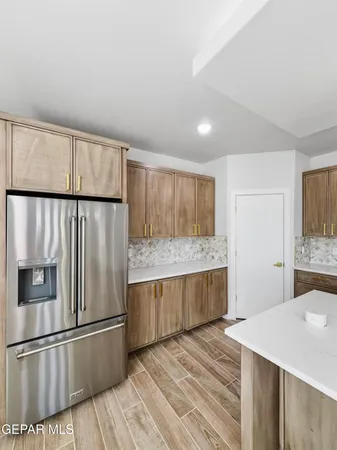 a kitchen with granite countertop a refrigerator and a stove top oven