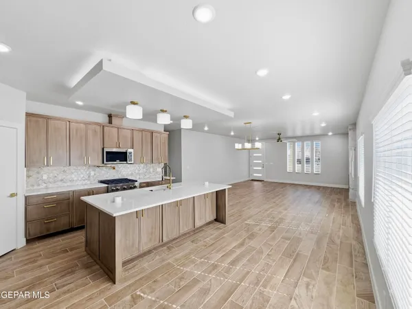 a large kitchen with stainless steel appliances lots of counter space and wooden floor