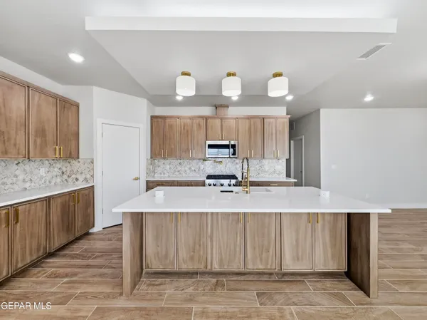 a large kitchen with a wooden floor and stainless steel appliances