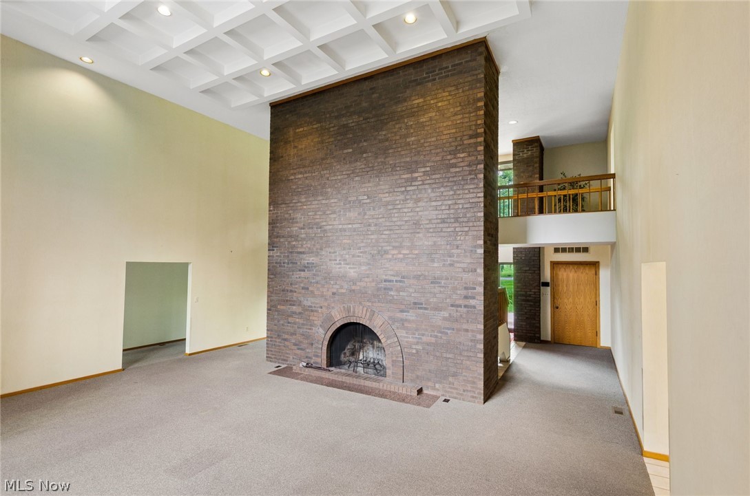 200 Hampshire Road Akron, OH 44313 - Photo 7 of 50 Vaulted ceiling with recessed lighting, exposed brick fireplace, and upper-level interior balcony with wood railing