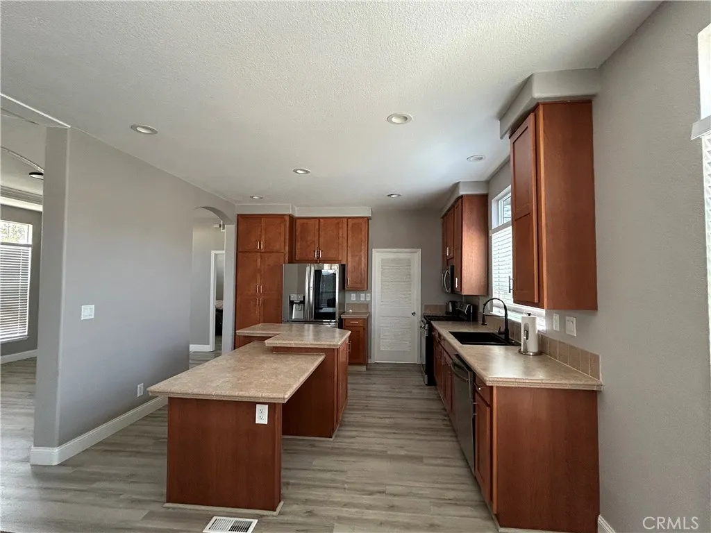 10550 Western, Unit 32 Stanton, CA 90680 - Photo 14 of 31 a kitchen with stainless steel appliances granite countertop a stove a sink dishwasher and a refrigerator with wooden floor