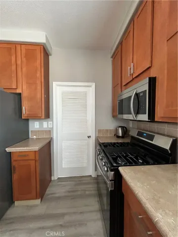 a kitchen with stainless steel appliances granite countertop a stove a sink and a microwave