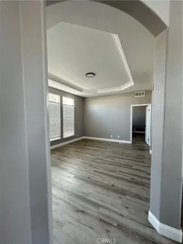 a view of an empty room with wooden floor