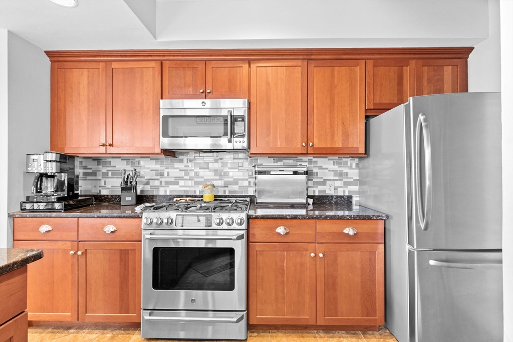 79 F Street Hull, MA 02045 - Photo 23 of 42 a kitchen with granite countertop a refrigerator stove and cabinets