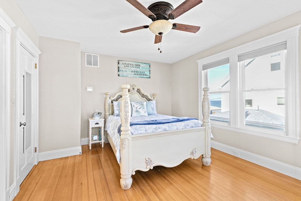 79 F Street Hull, MA 02045 - Photo 29 of 42 a bed room with a bed and a chandelier