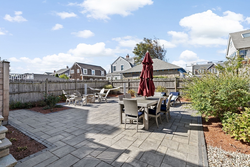 79 F Street Hull, MA 02045 - Photo 10 of 42 a view of a patio with dining table and chairs with wooden fence