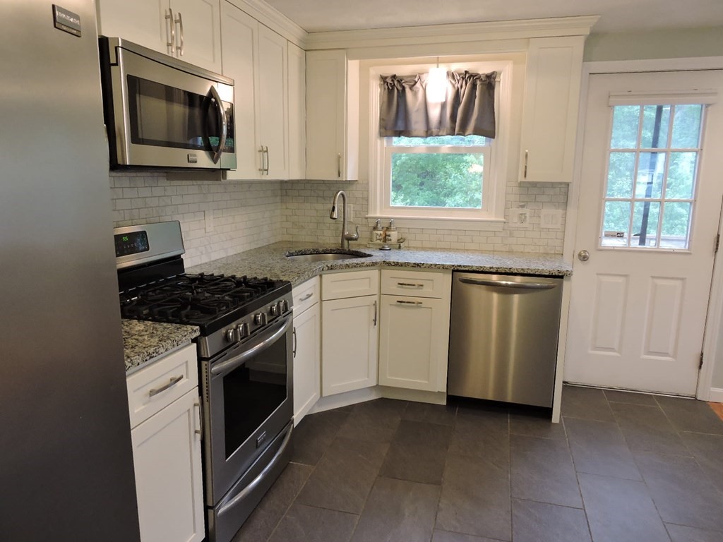 46 Lexington Road Billerica, MA 01821 - Photo 8 of 41 a kitchen with white cabinets appliances and window