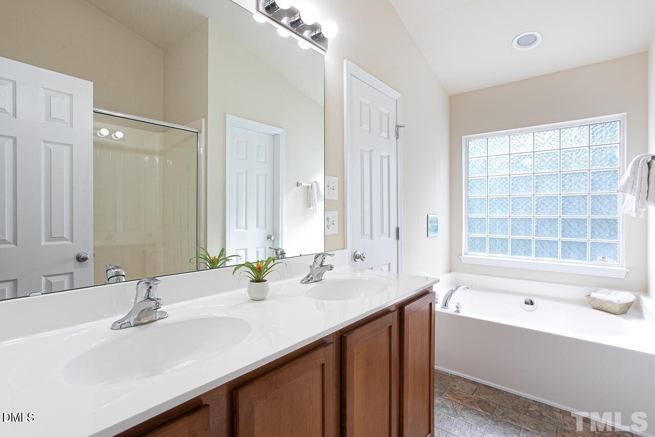 1662 Snow Mass Way Durham, NC 27713 - Photo 15 of 24 a bathroom with a sink double vanity granite tub shower and a mirror