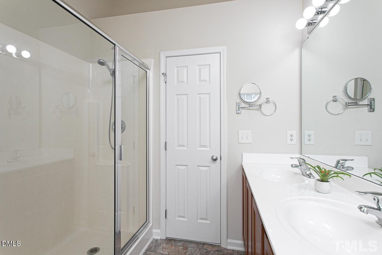 1662 Snow Mass Way Durham, NC 27713 - Photo 16 of 24 a bathroom with a sink a mirror and shower