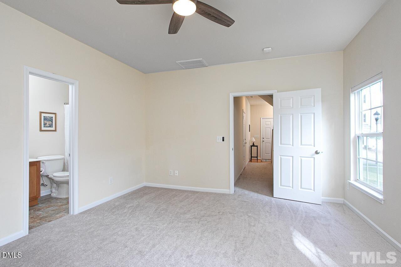 1662 Snow Mass Way Durham, NC 27713 - Photo 22 of 24 an empty room with chandelier fan and windows