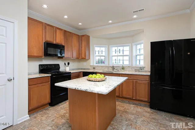 a kitchen with stainless steel appliances granite countertop a stove a sink and a refrigerator