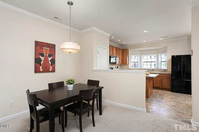 a dining room with a table chairs and kitchen view