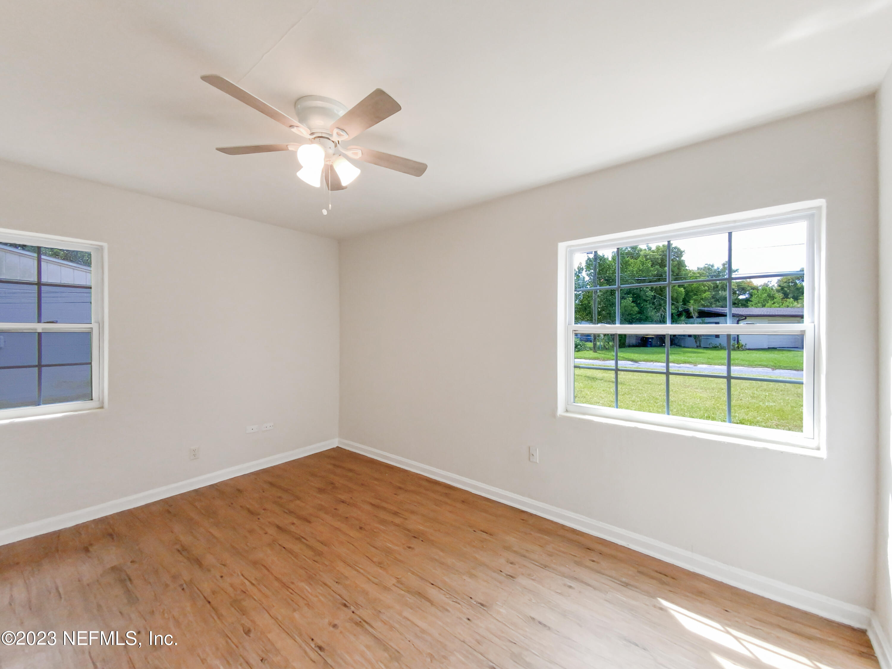 6231 Commodore Drive Jacksonville, FL 32244 - Photo 13 of 18 a view of an empty room with wooden floor and a window