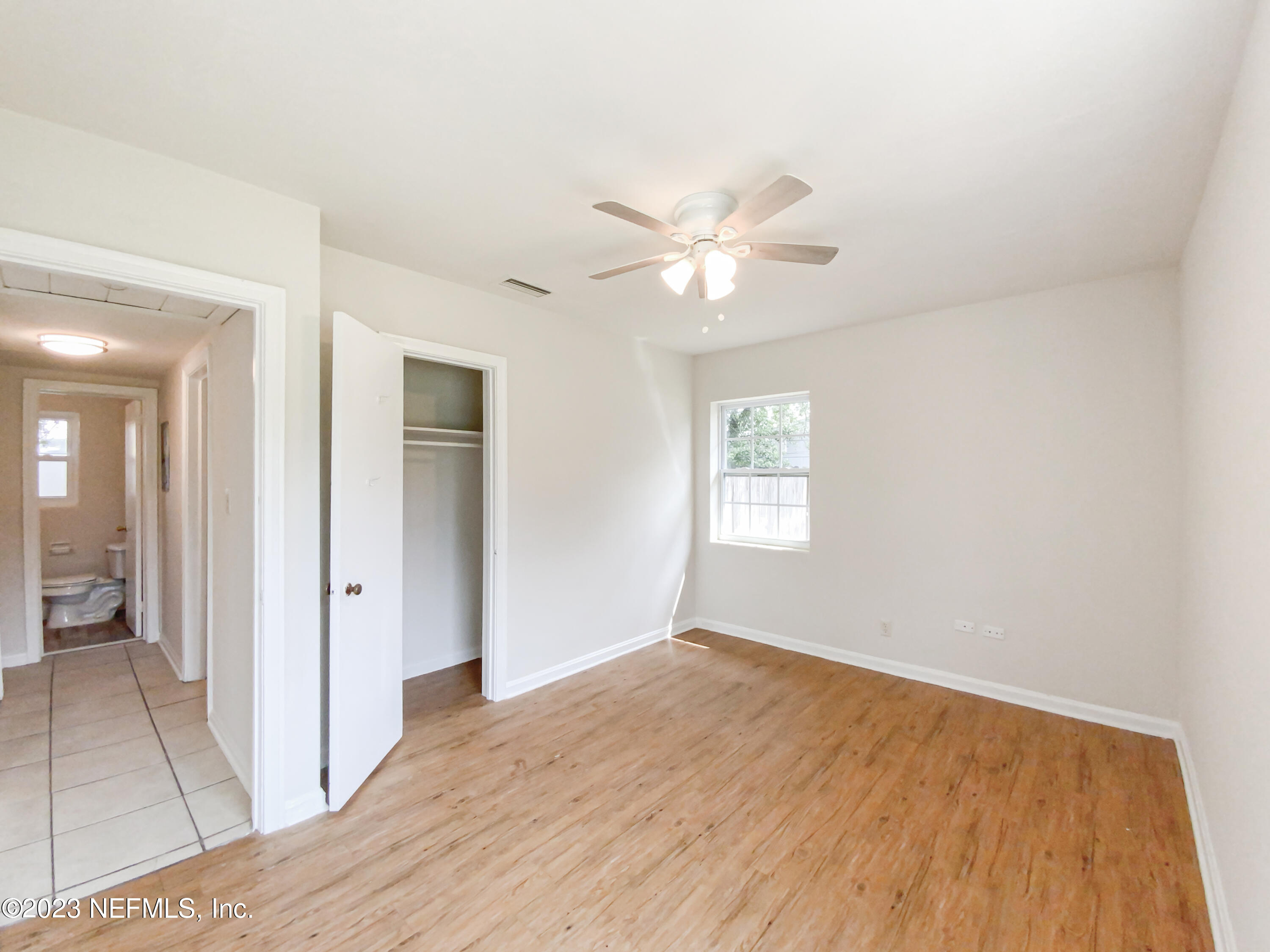6231 Commodore Drive Jacksonville, FL 32244 - Photo 14 of 18 wooden floor in an empty room with a window