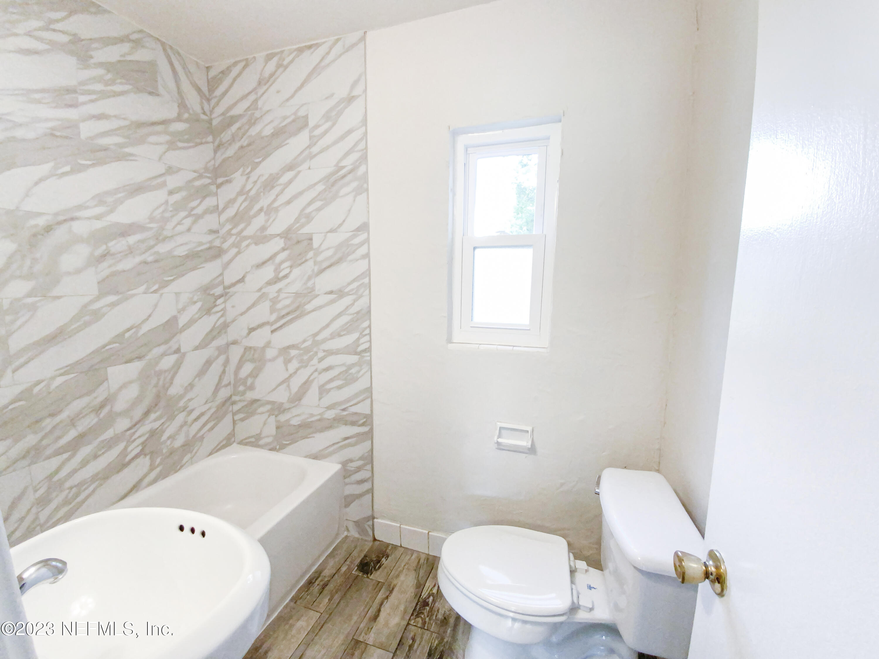 6231 Commodore Drive Jacksonville, FL 32244 - Photo 16 of 18 a white toilet sitting next to a bathroom sink and tub