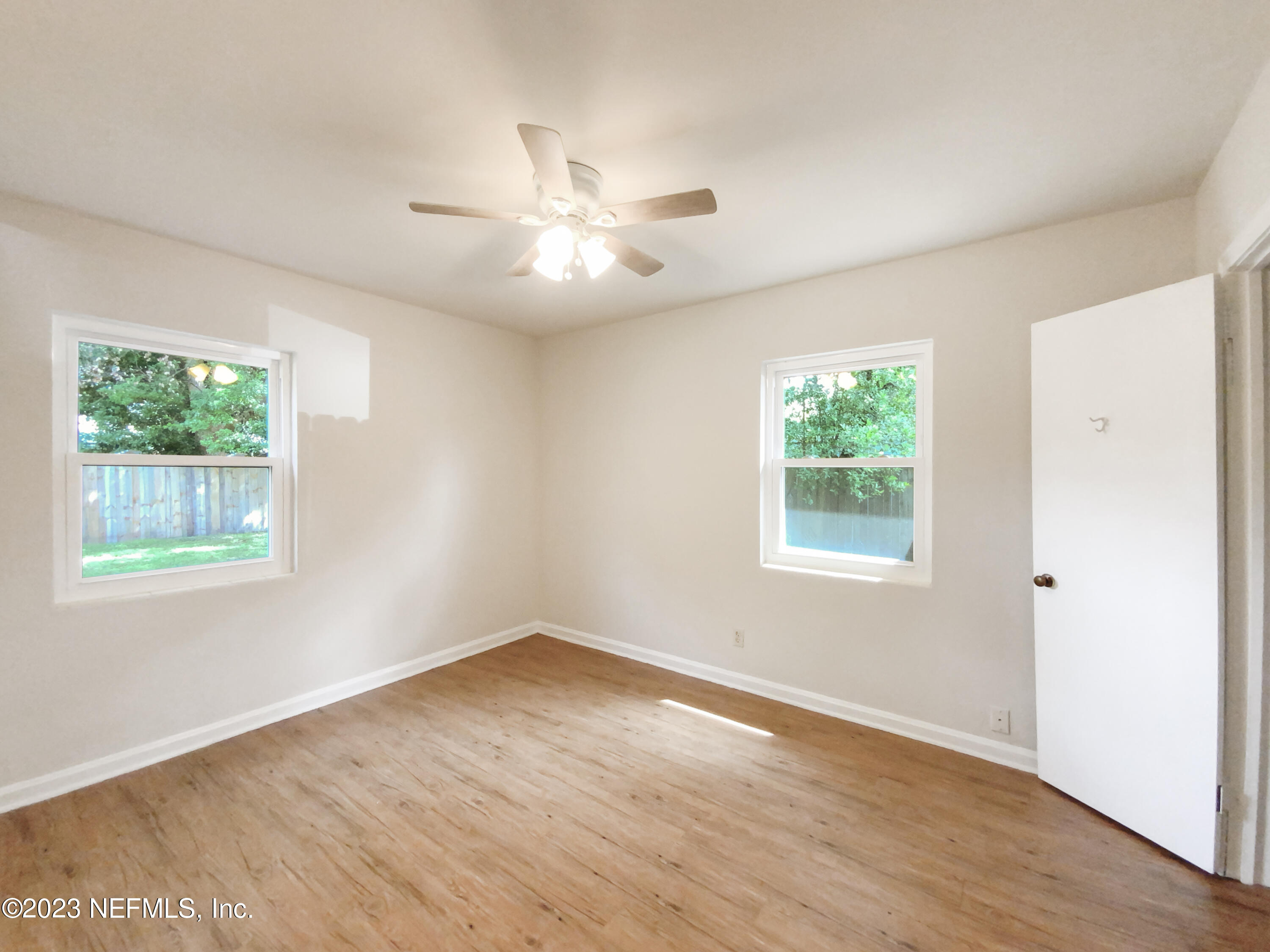 6231 Commodore Drive Jacksonville, FL 32244 - Photo 5 of 18 a view of an empty room with wooden floor and a window