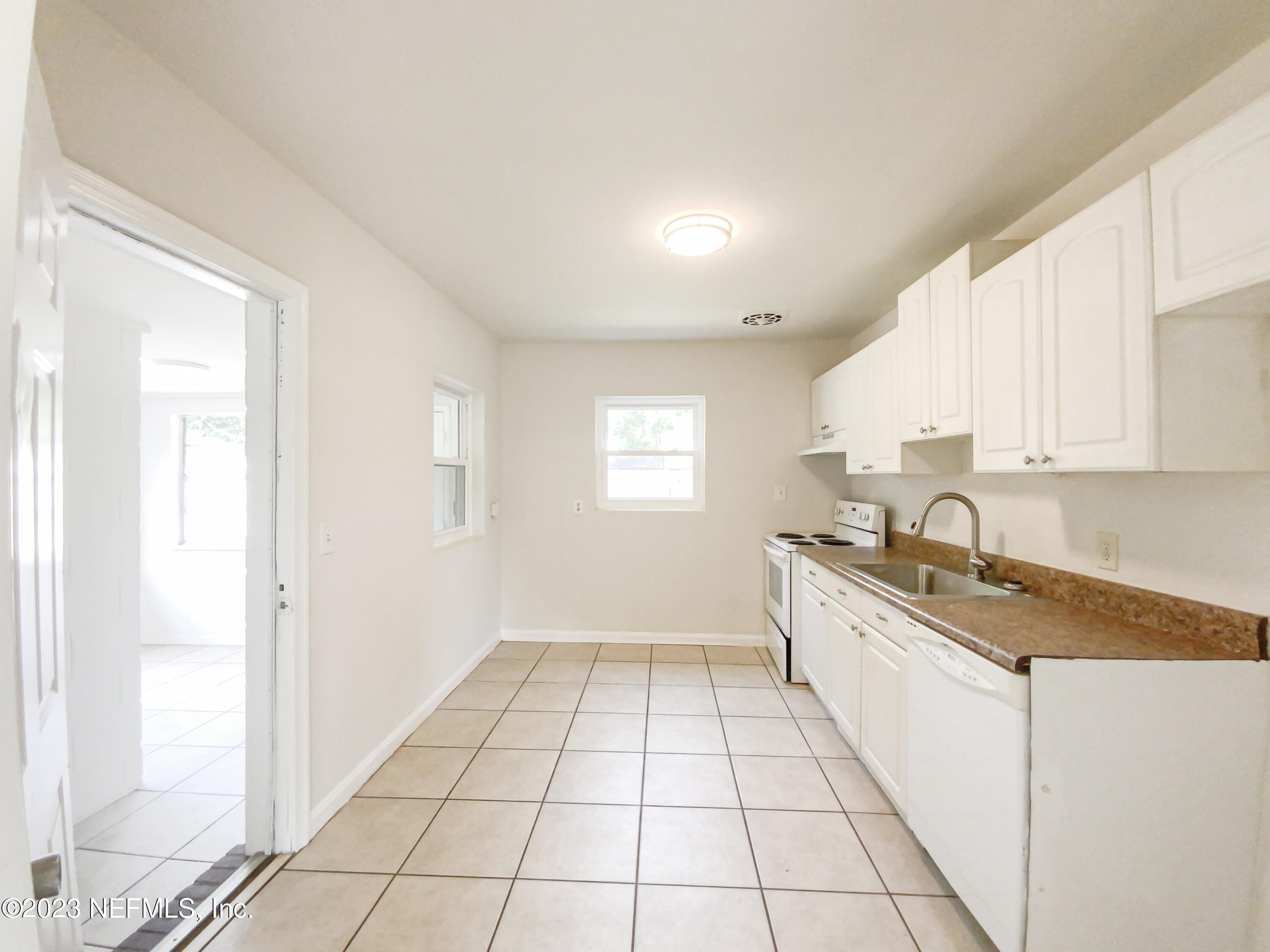 6231 Commodore Drive Jacksonville, FL 32244 - Photo 6 of 18 a kitchen with a sink a stove cabinets and a window