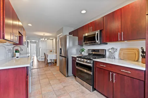 a kitchen with stainless steel appliances granite countertop a refrigerator stove and sink