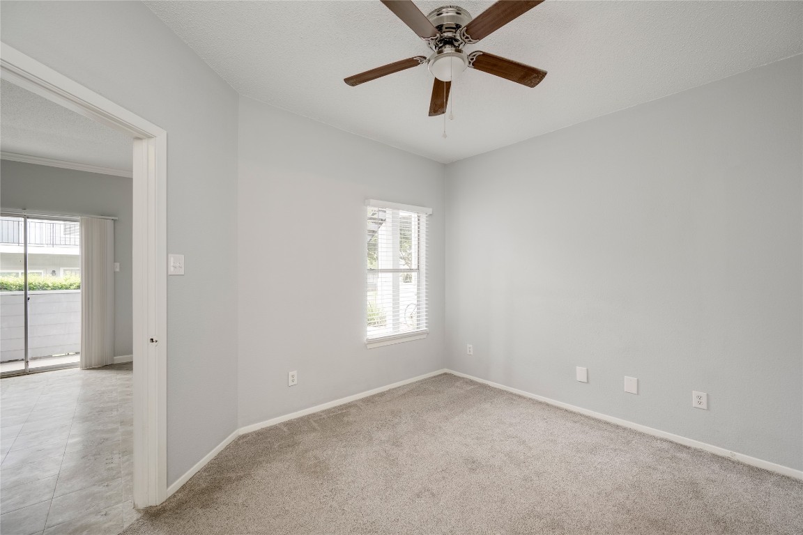12166 Metric Boulevard, Unit 129 Austin, TX 78758 - Photo 11 of 38 Spare room with a ceiling fan and light carpet