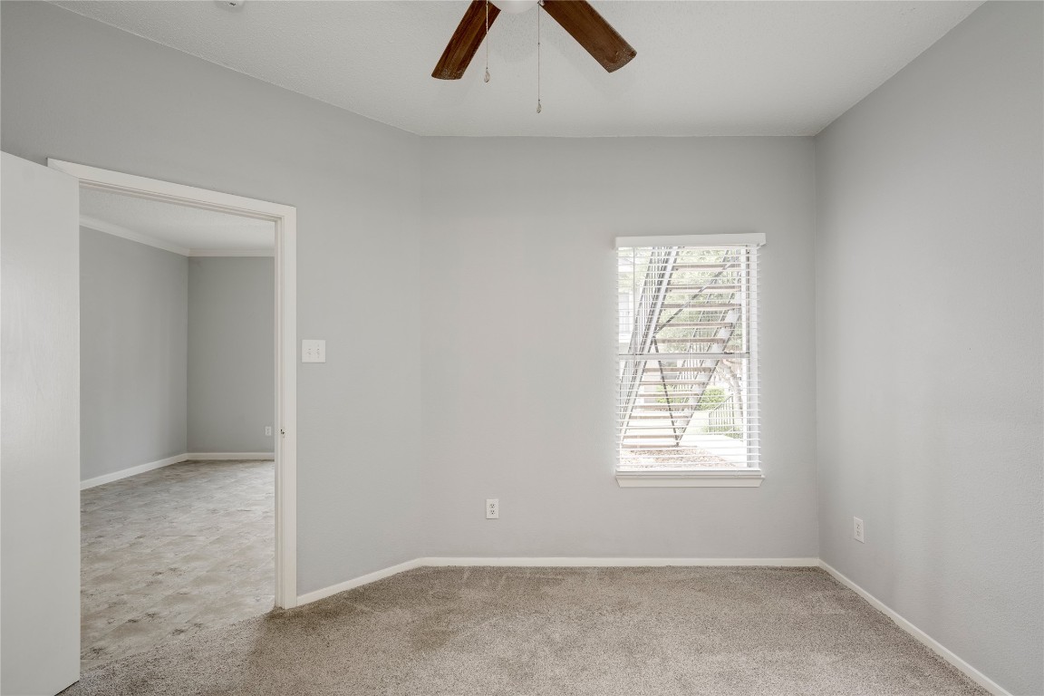 12166 Metric Boulevard, Unit 129 Austin, TX 78758 - Photo 12 of 38 Empty room with a ceiling fan and carpet