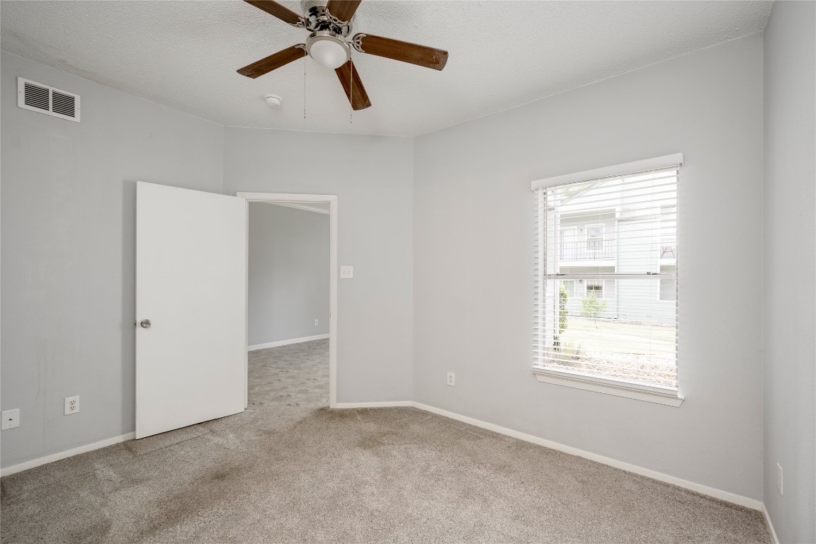 12166 Metric Boulevard, Unit 129 Austin, TX 78758 - Photo 13 of 38 Carpeted empty room featuring ceiling fan and baseboards