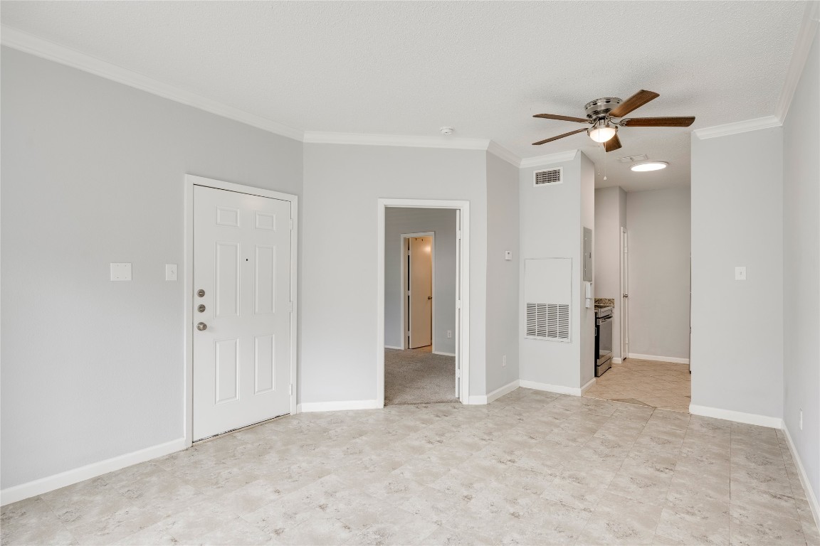 12166 Metric Boulevard, Unit 129 Austin, TX 78758 - Photo 18 of 38 Empty room with ornamental molding and a ceiling fan