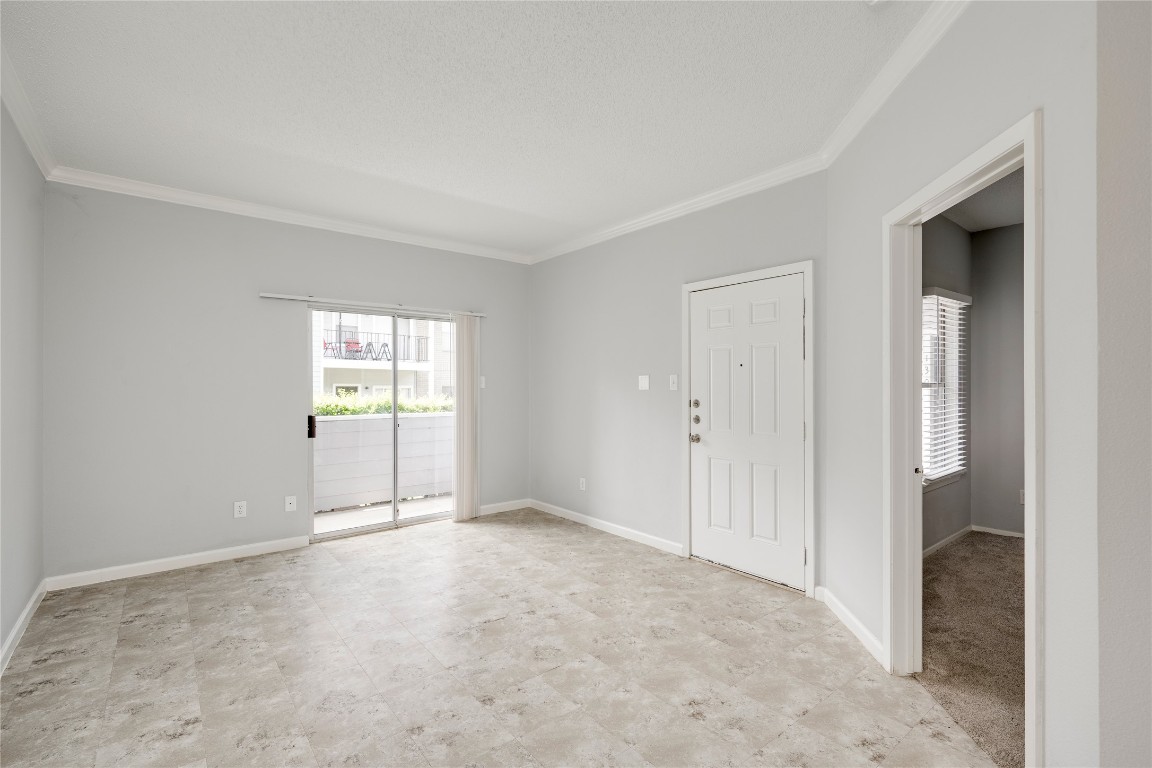 12166 Metric Boulevard, Unit 129 Austin, TX 78758 - Photo 19 of 38 Empty room featuring crown molding