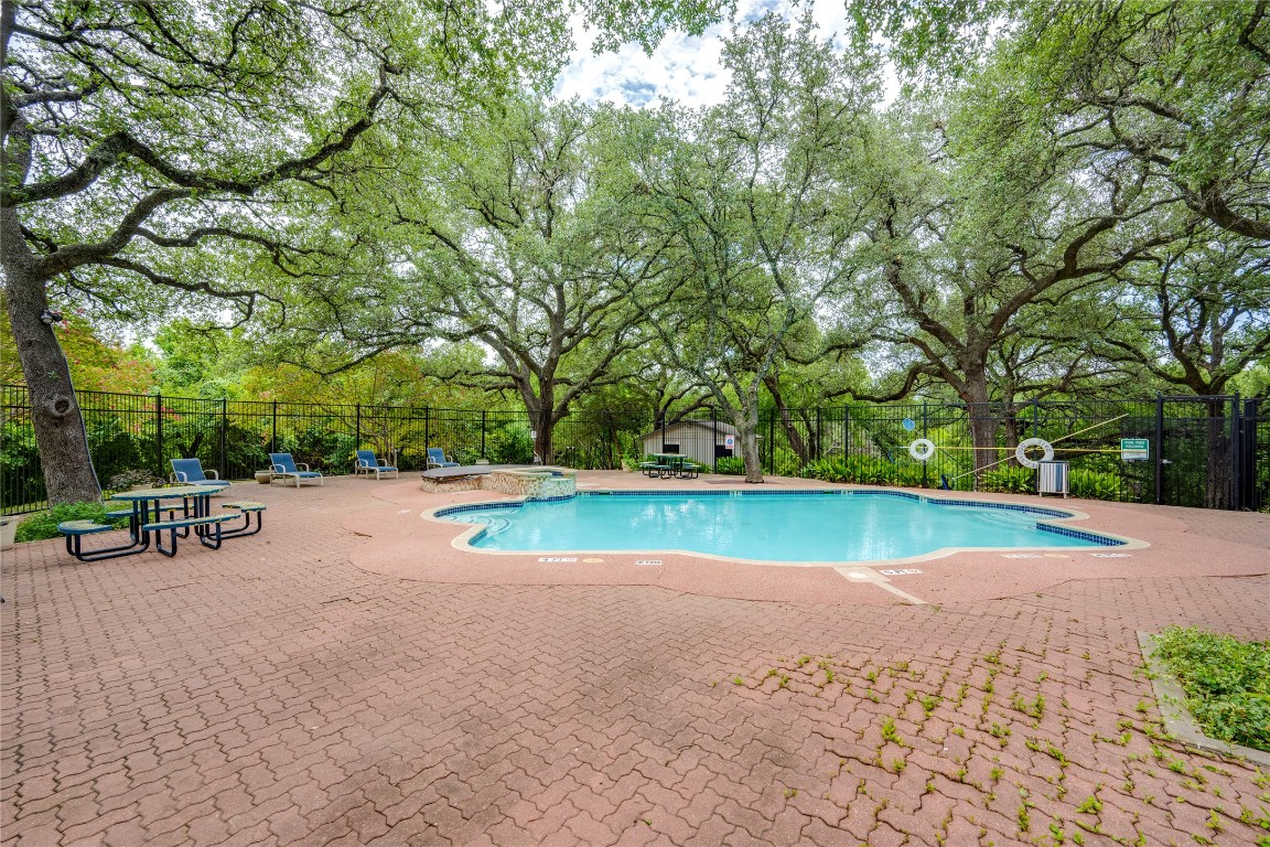 12166 Metric Boulevard, Unit 129 Austin, TX 78758 - Photo 32 of 38 Community pool with a patio and view of wooded area