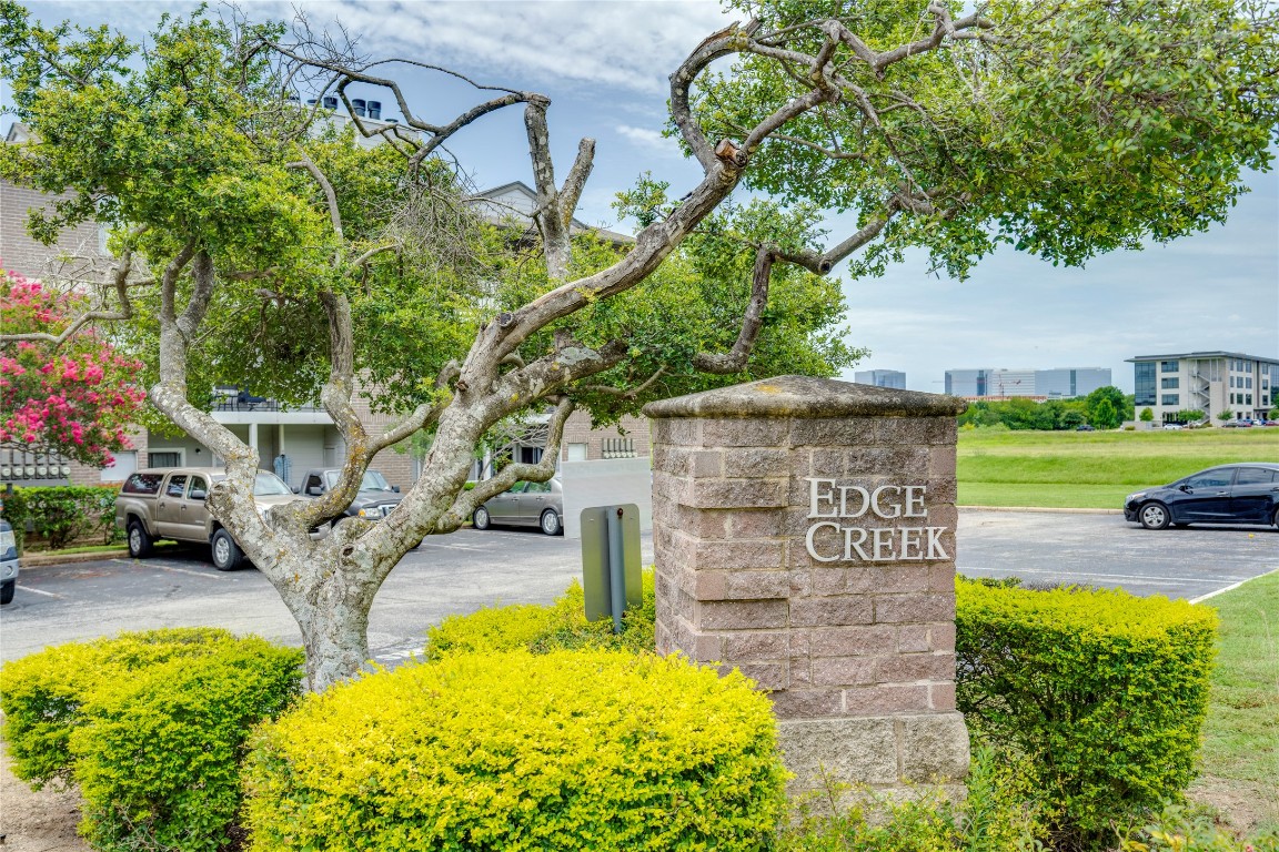12166 Metric Boulevard, Unit 129 Austin, TX 78758 - Photo 37 of 38 Community sign featuring uncovered parking