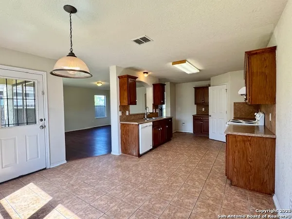 a kitchen with stainless steel appliances granite countertop a stove refrigerator and cabinets