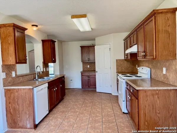 a kitchen with stainless steel appliances granite countertop a stove a sink dishwasher and a refrigerator